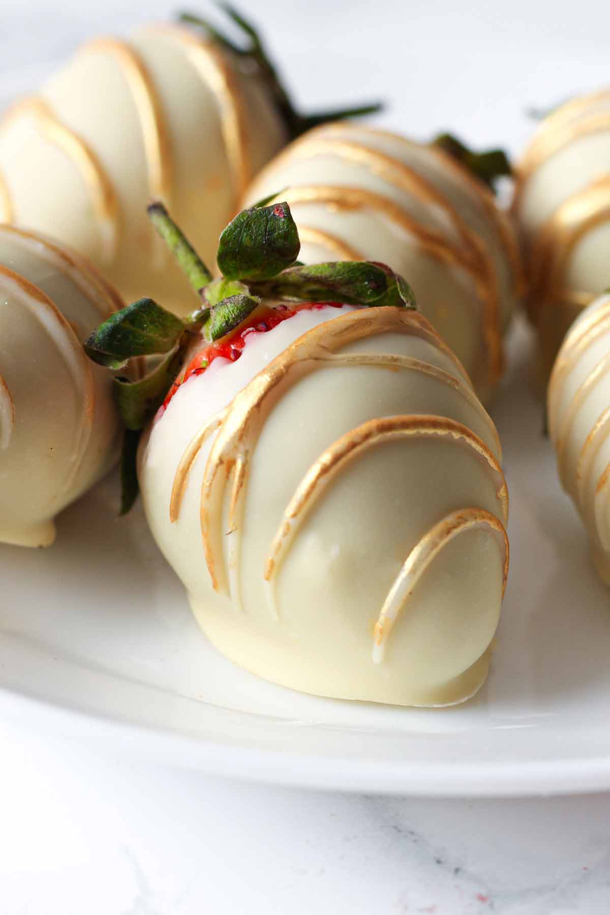 white chocolate strawberries with metallic gold drizzle on top