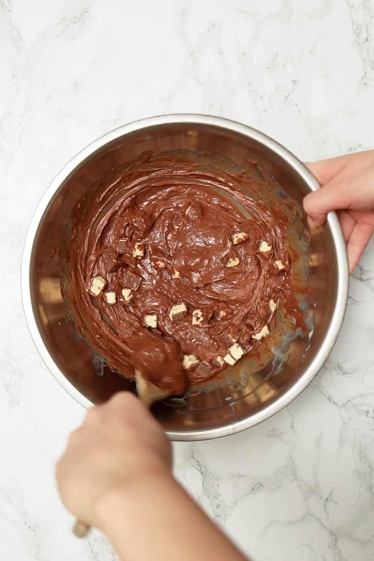 stirring chocolate bar pieces into the mixture