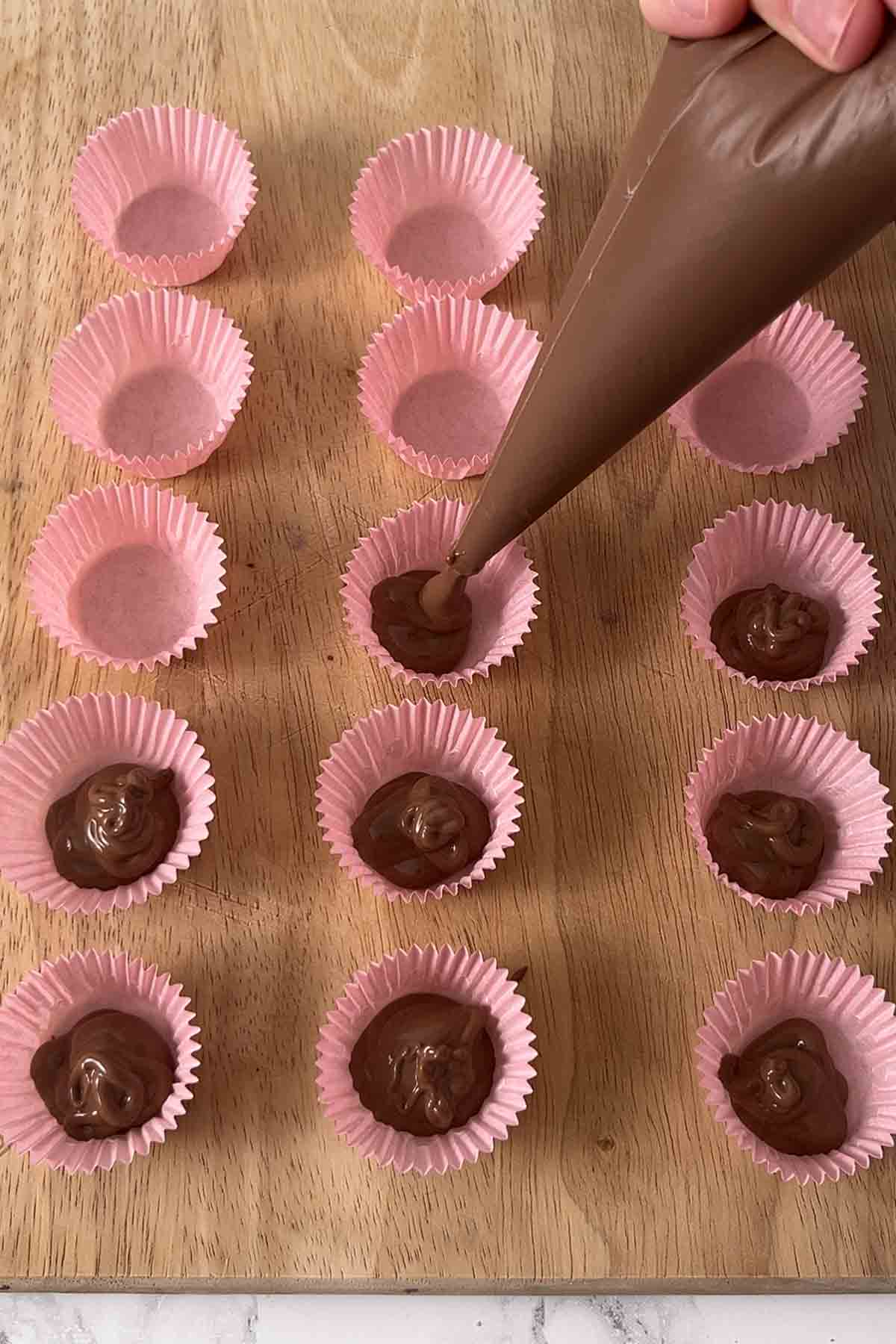 piping chocolate into petit four cases