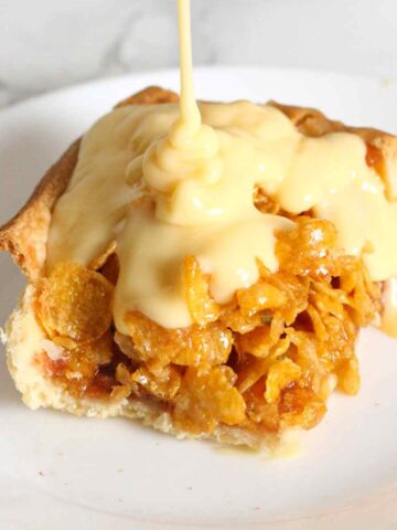 a slice of cornflake traybake with custard