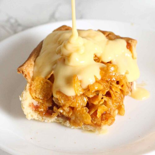 a slice of cornflake traybake with custard