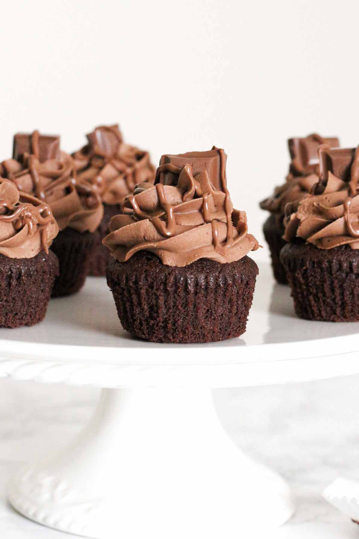 chocolate dairy milk cupcakes on a white cake stand
