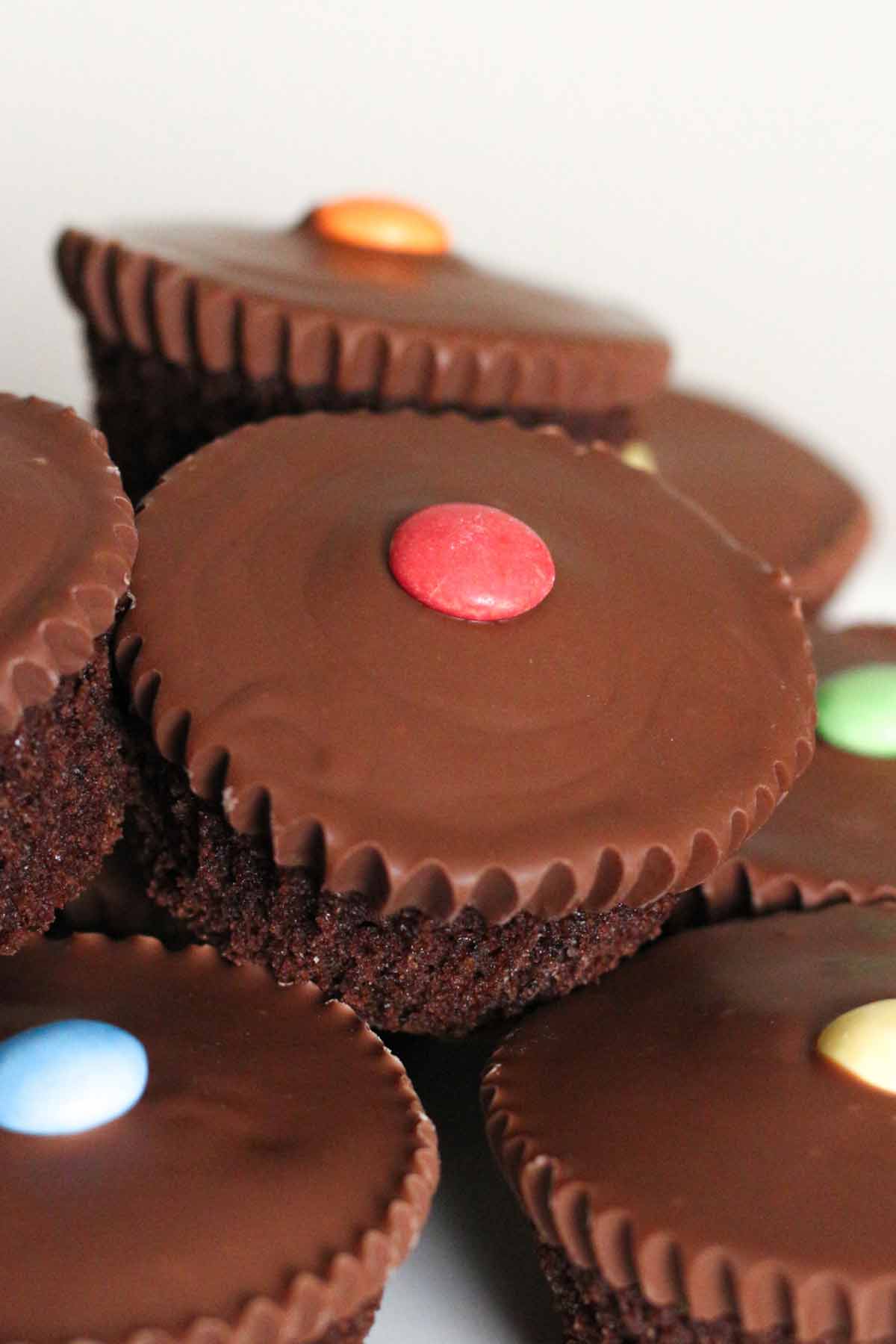 pile of nestle smarties cupcakes with chocolate on top