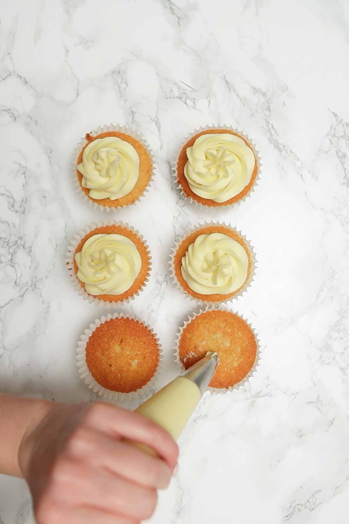 piping milky bar buttercream onto cupcakes