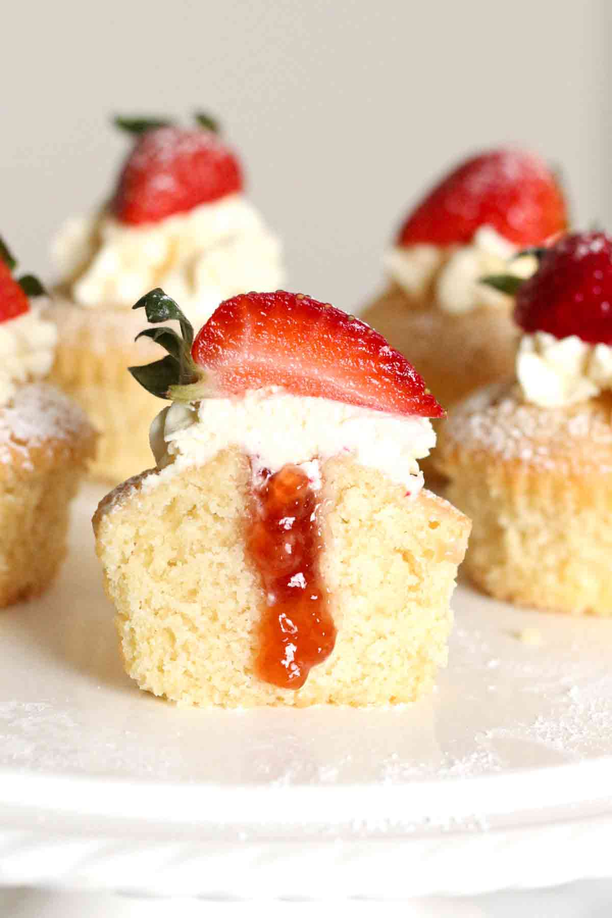 victoria sponge cupcake cut in half to show jam filling