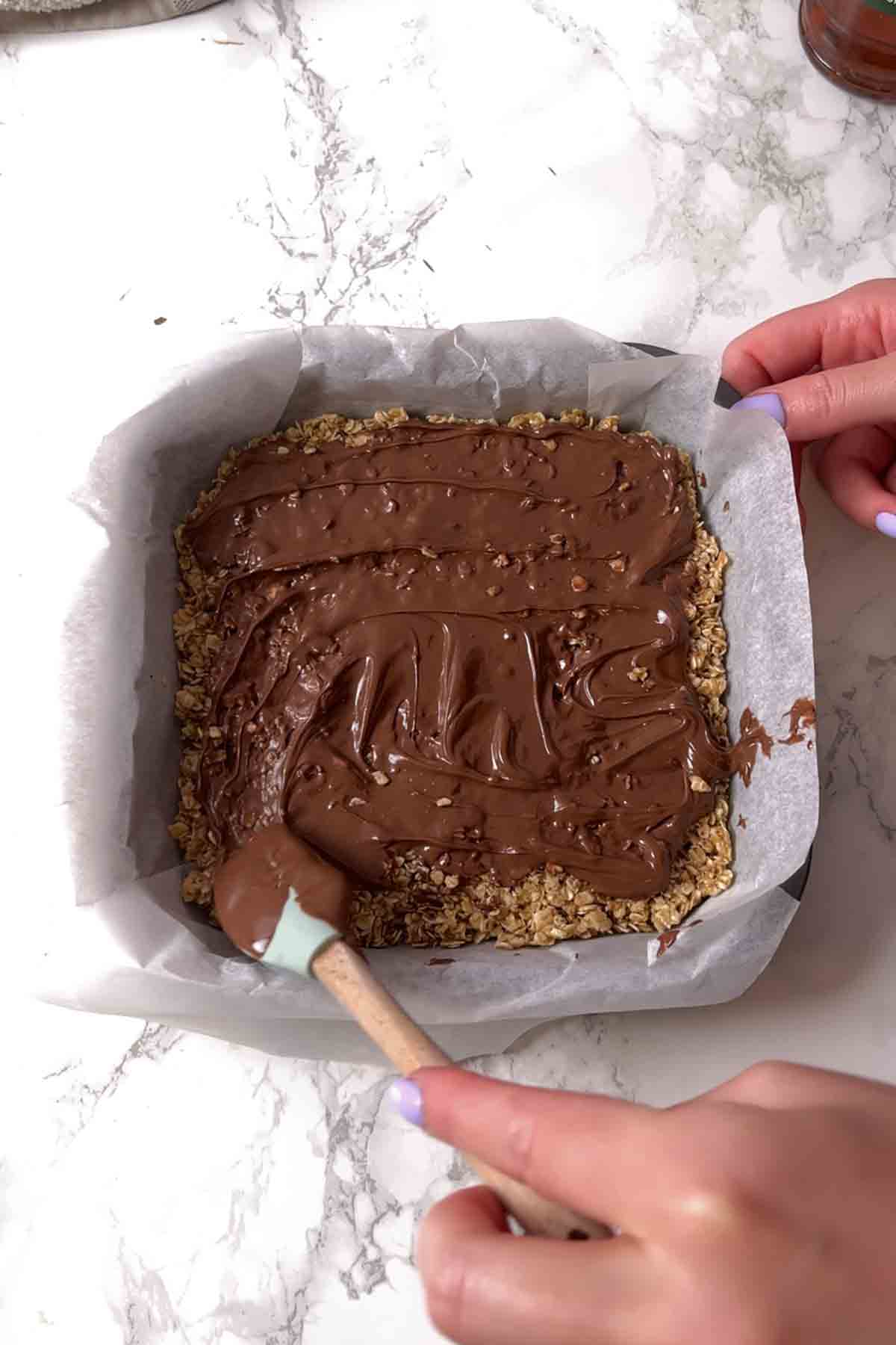 half of flapjack mixture topped with melted Nutella
