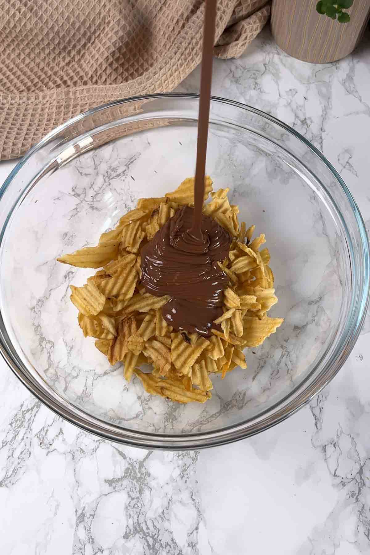 pouring melted chocolate into the bowl with the chips