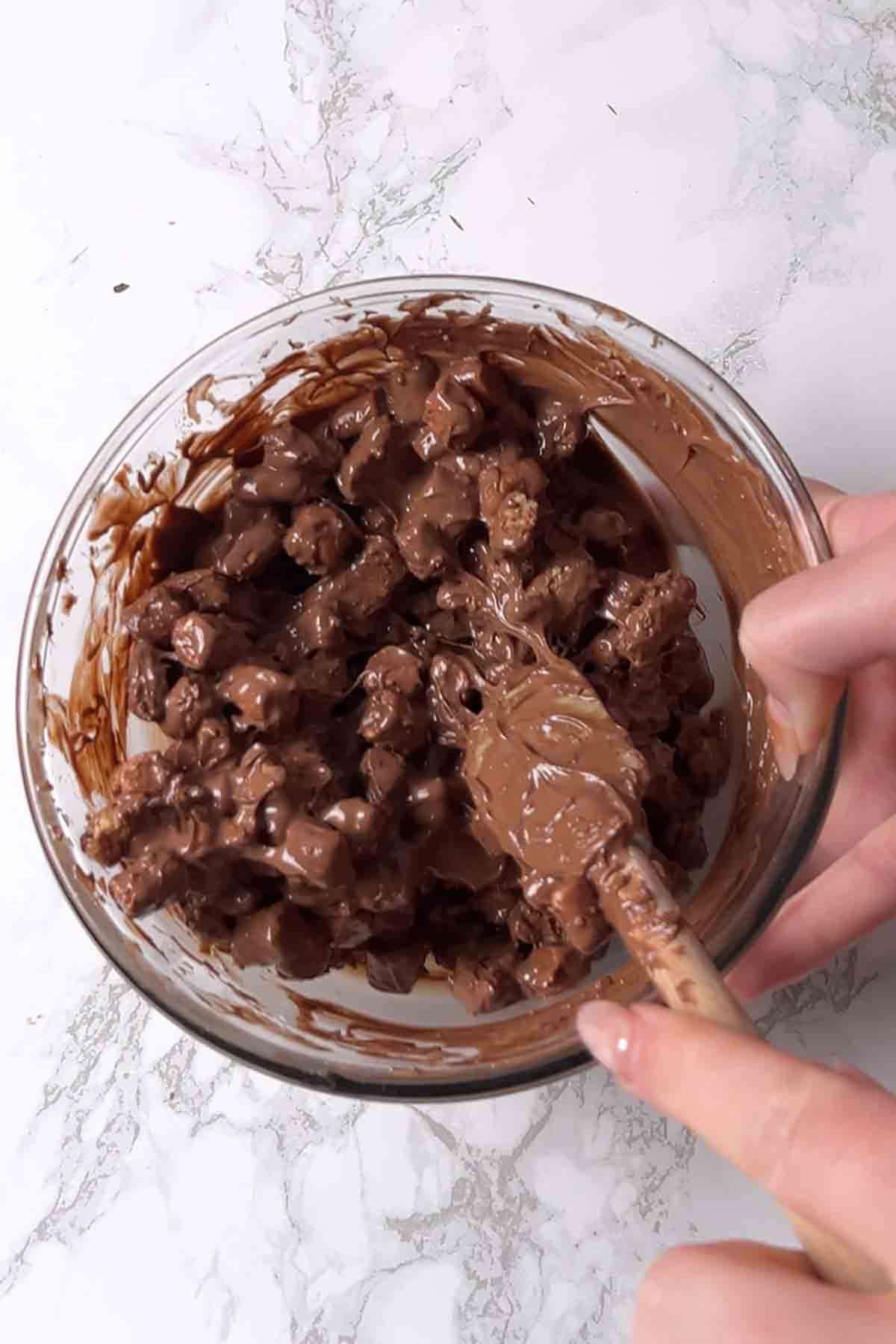 mixing the melted chocolate with marshmallows and crackers