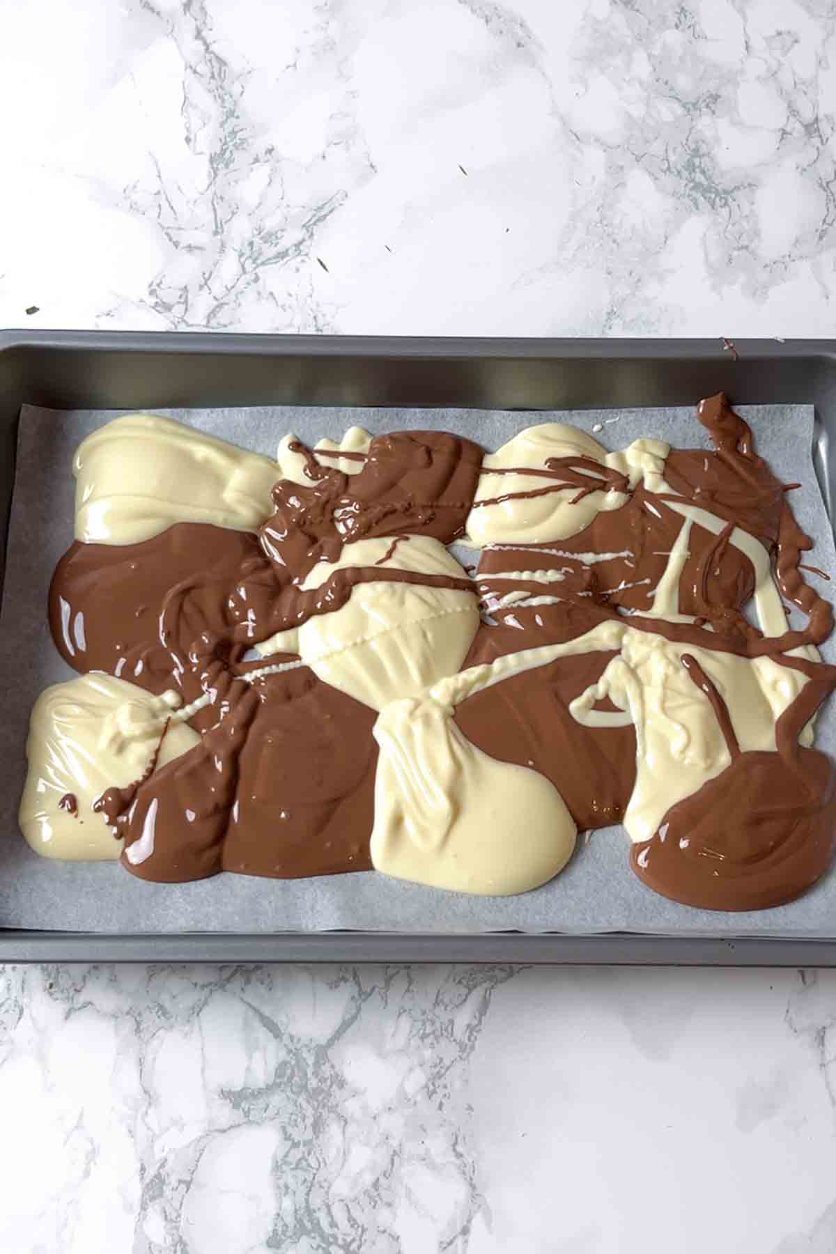 spoonfuls of melted milk and white chocolate on a tray
