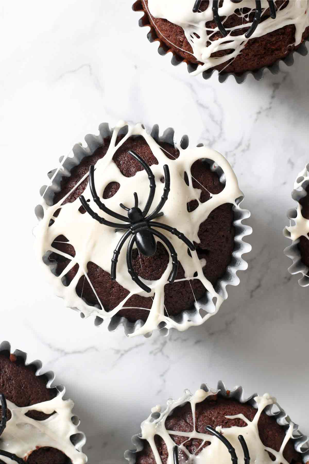 overhead image of spider web muffins with marshmallow on top