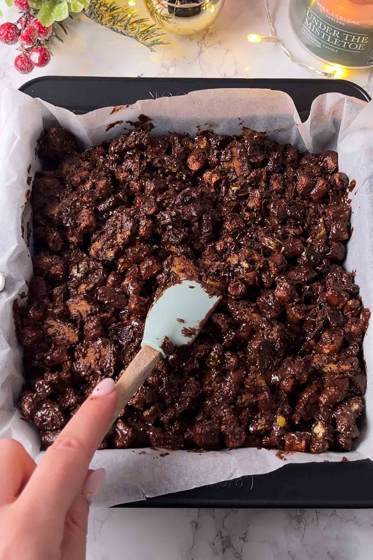 pressing the traybake mixture into tin