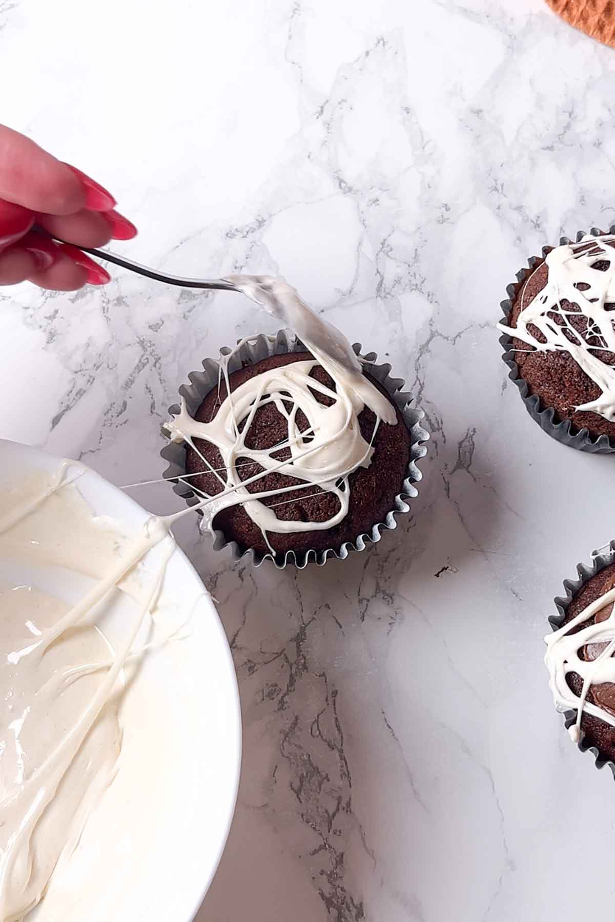 putting melted marshmallows on top of muffins