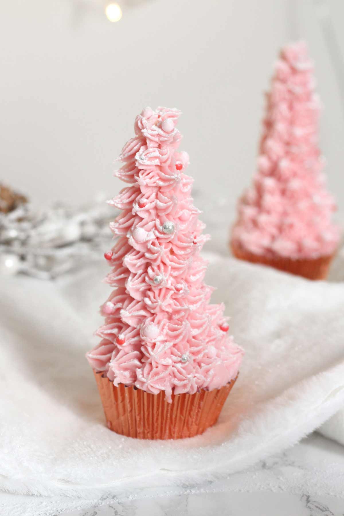 pink christmas tree cupcakes with sprinkles on them