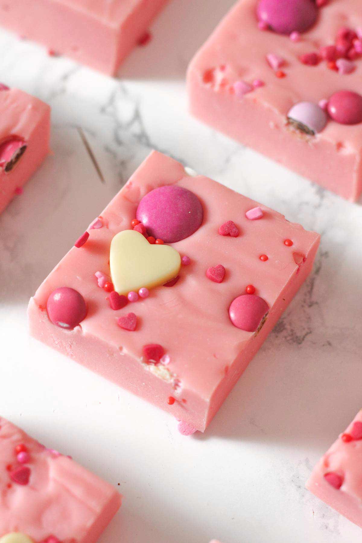 squares of valentines day pink fudge on a worktop