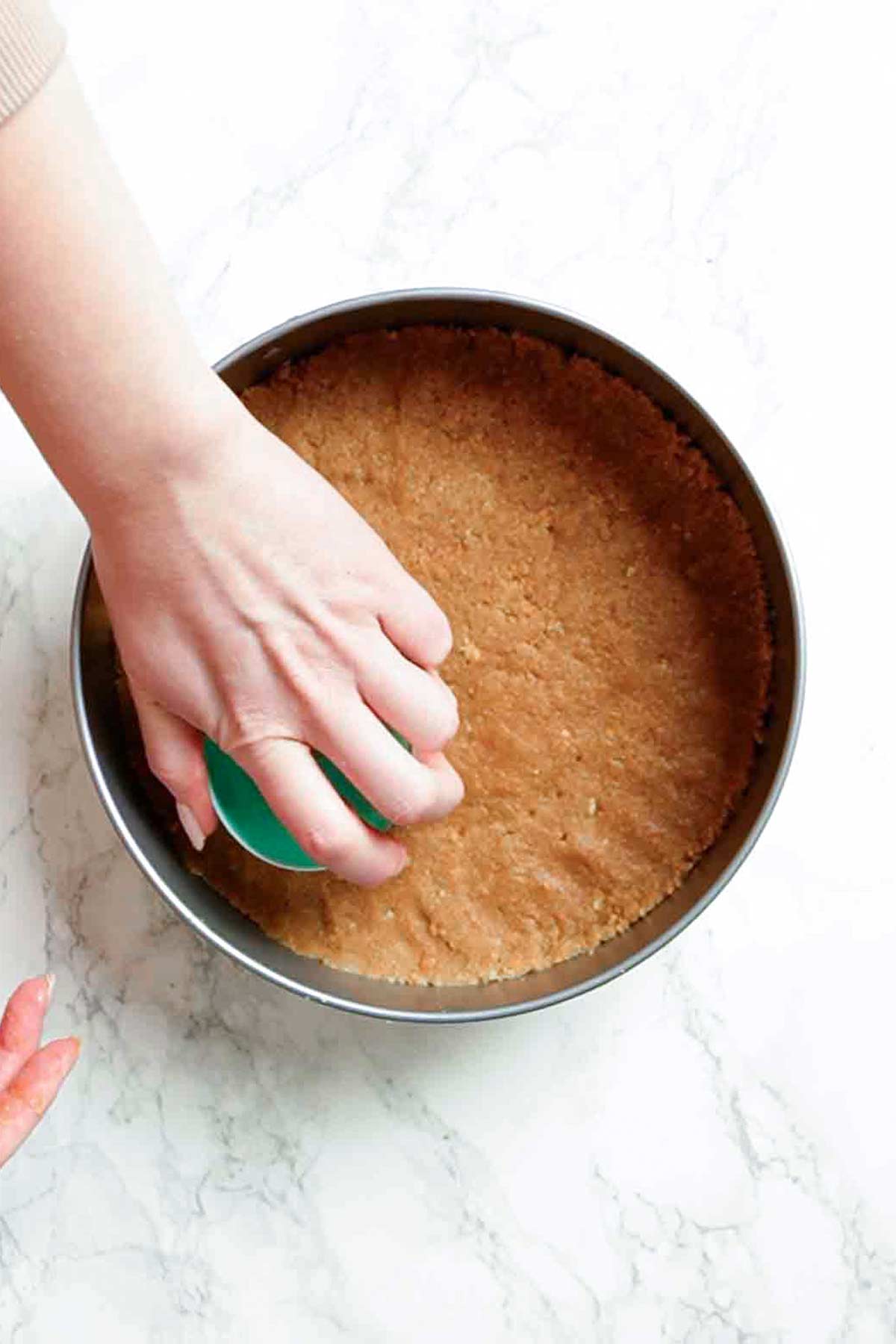 pressing digestive biscuit base into springform tin 