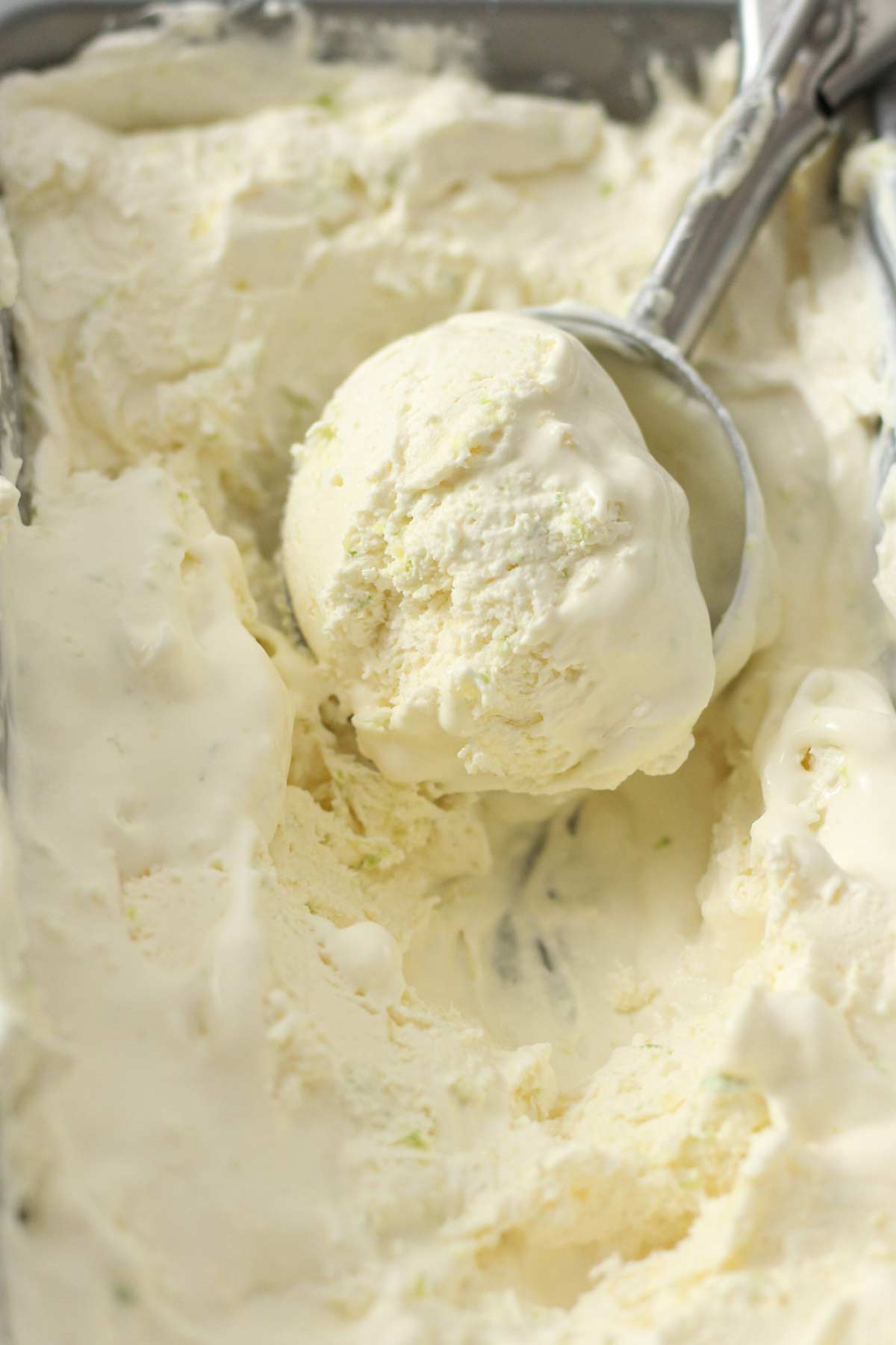lemon lime ice cream in tub with a scoop