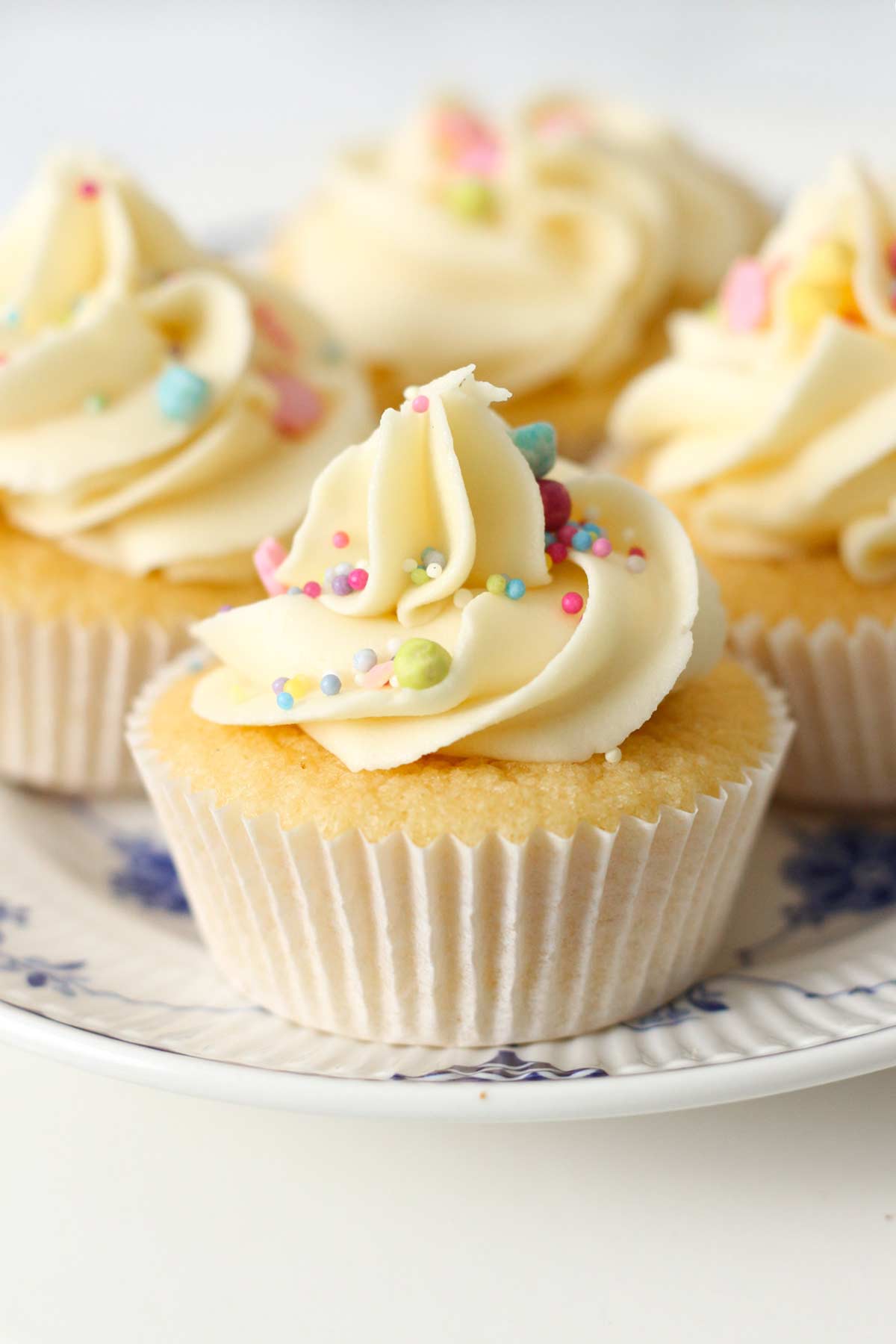 4 mini vanilla fairy cakes with buttercream on a plate