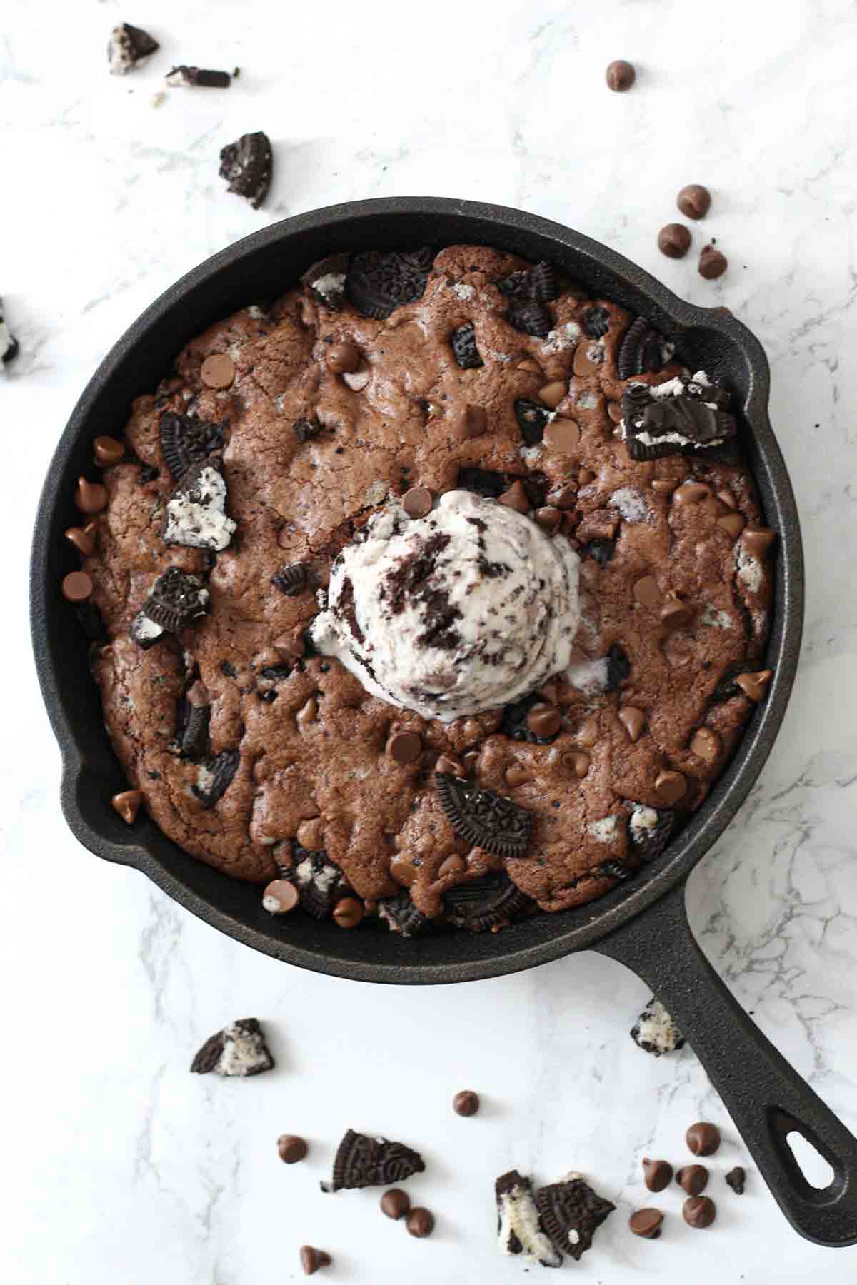 chocolate oreo pizookie in a skillet with cookies and cream ice cream on top