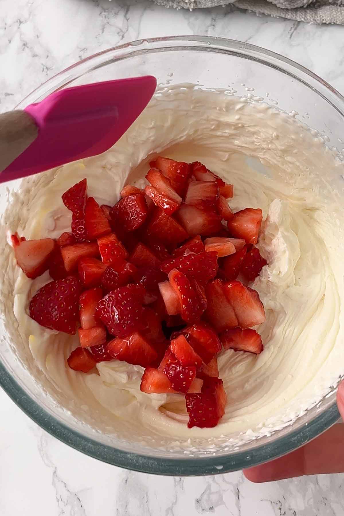 chopped strawberries in a bowl with cheesecake filling