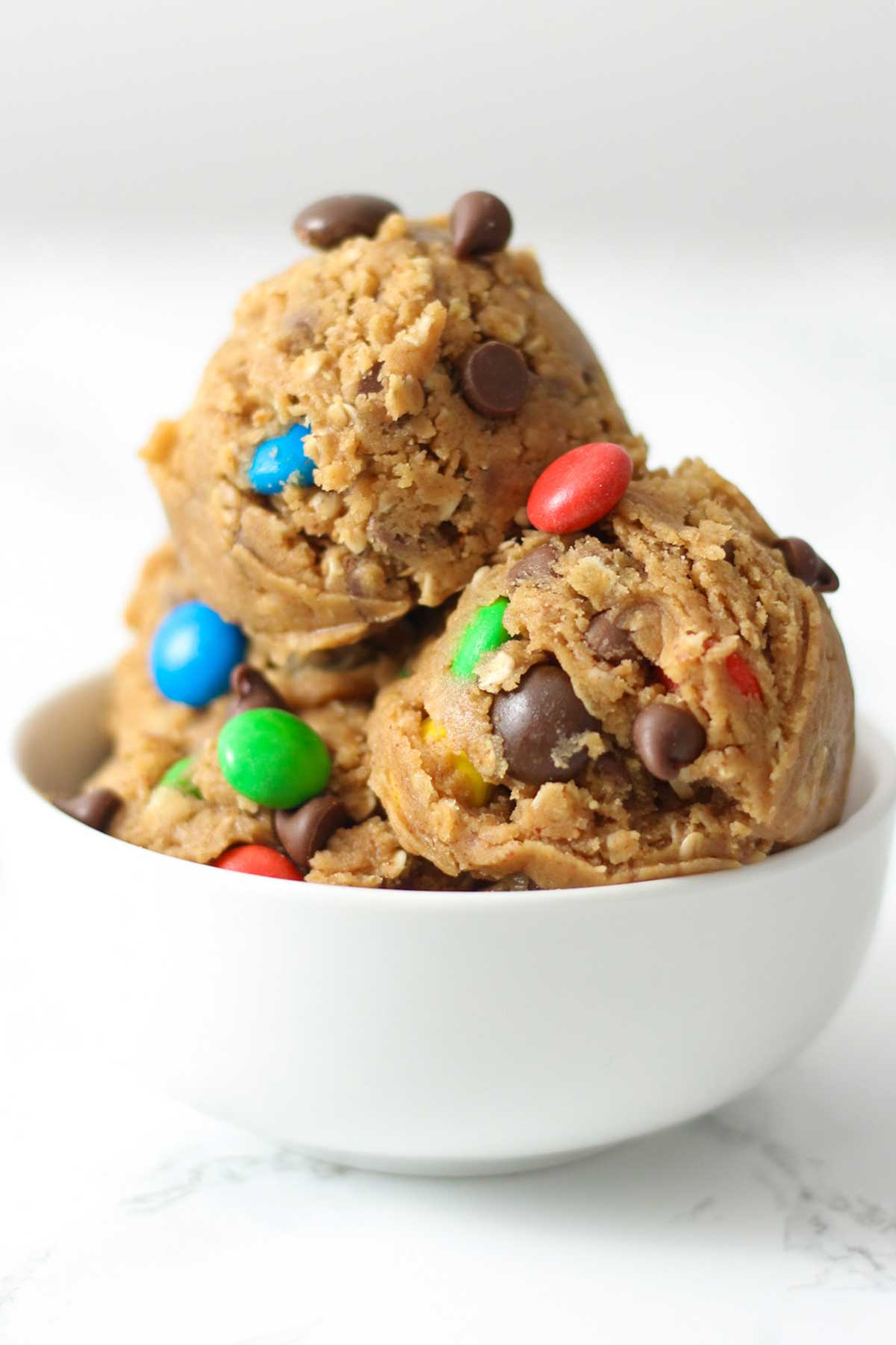 scoops of edible monster cookie dough in a white bowl