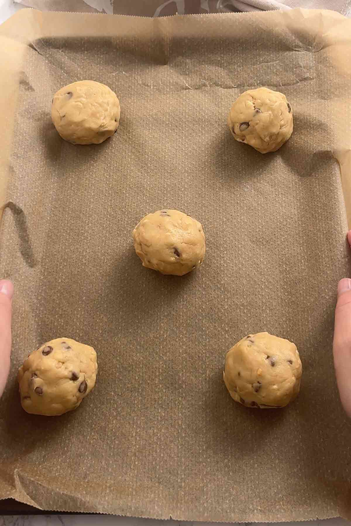balls of krispie cookie dough on a lined baking tray