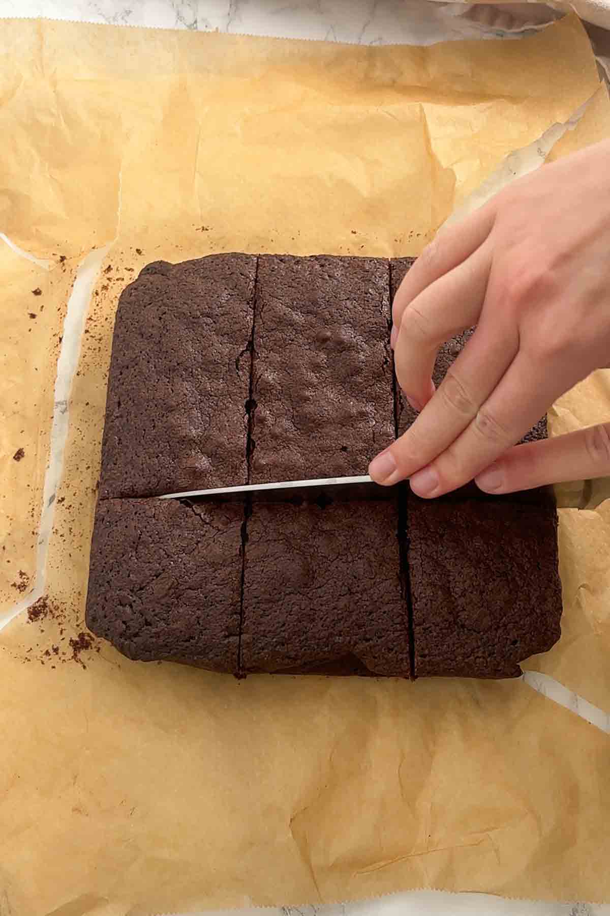 slicing baked brownies on worktop