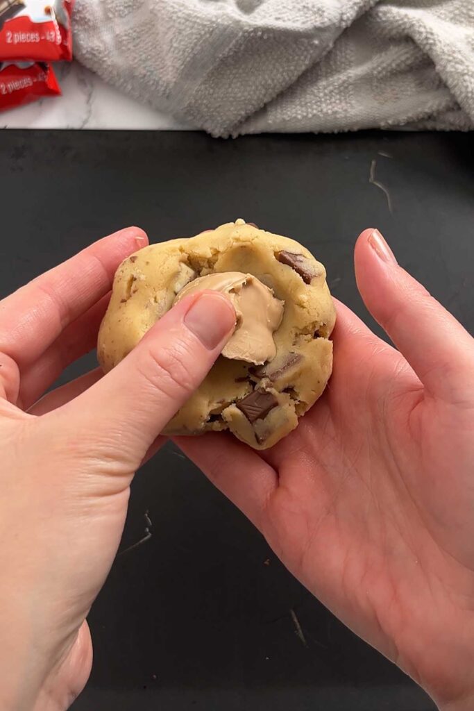 placing frozen white chocolate hazelnut spread inside cookie dough ball