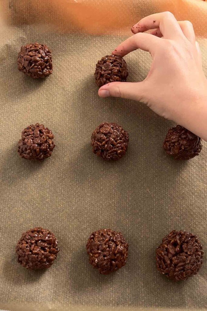 chocolate rice krispie balls on a lined baking tray