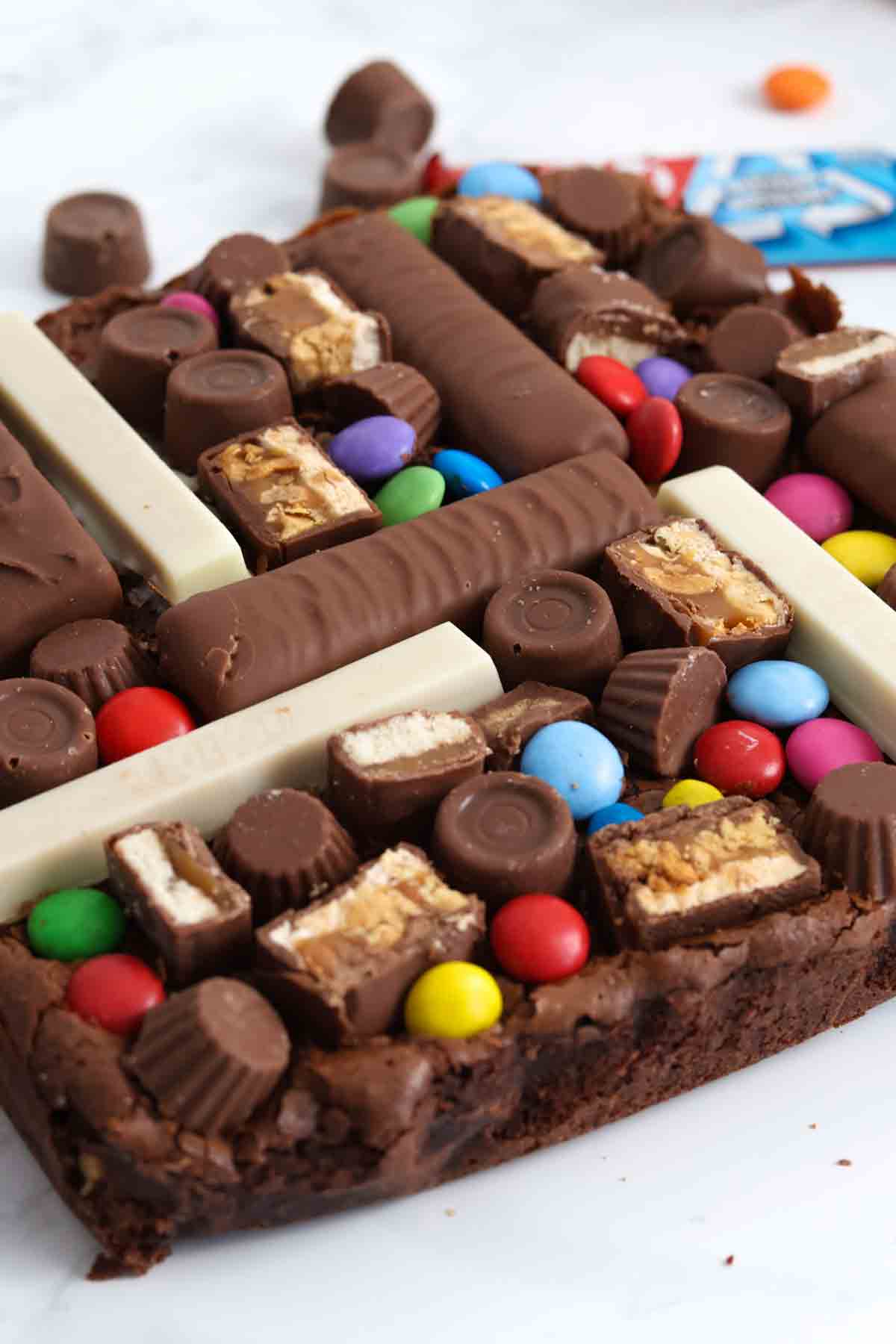 close up of brownie slab with leftover halloween candy on top