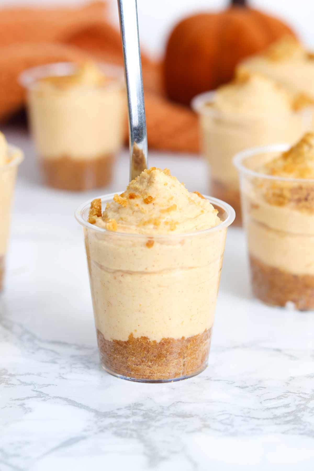 no bake pumpkin cheesecake shots on a white worktop