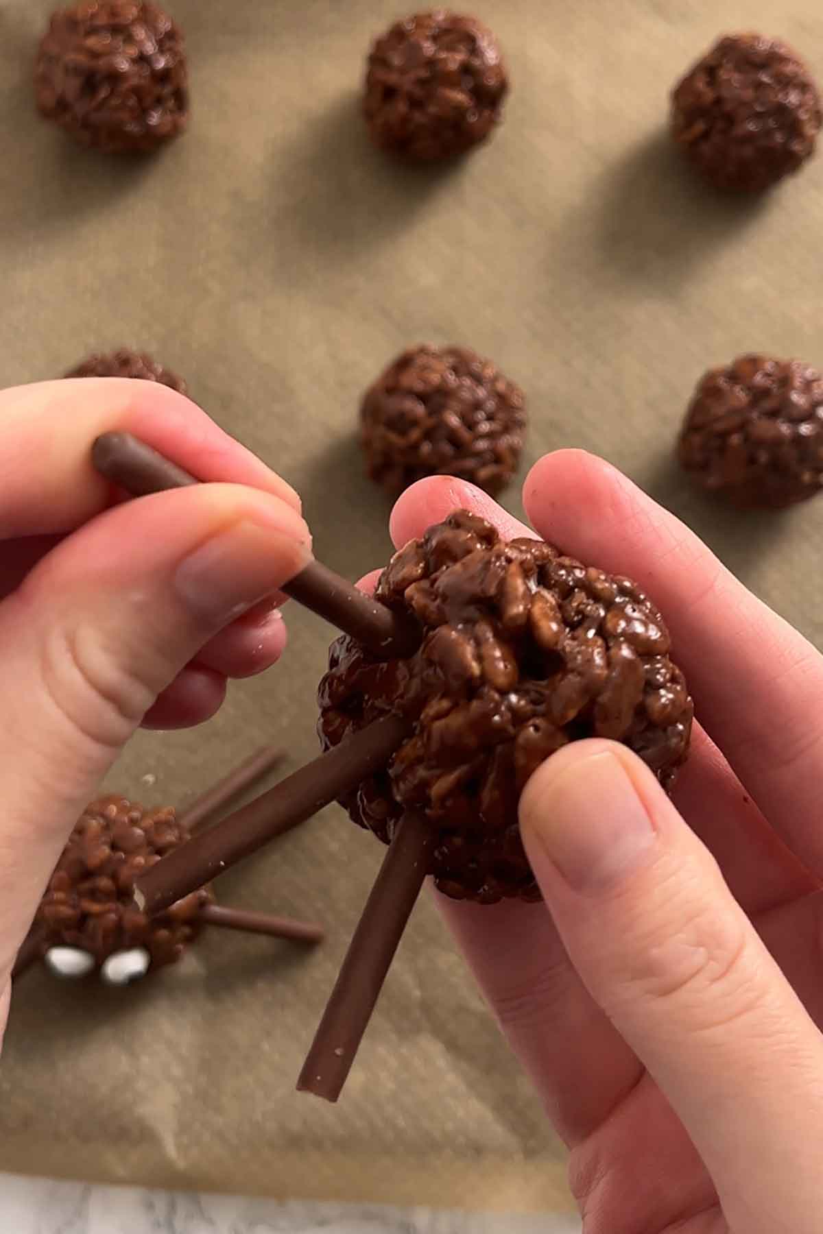 pressing pretzel stick into rice krispie balls
