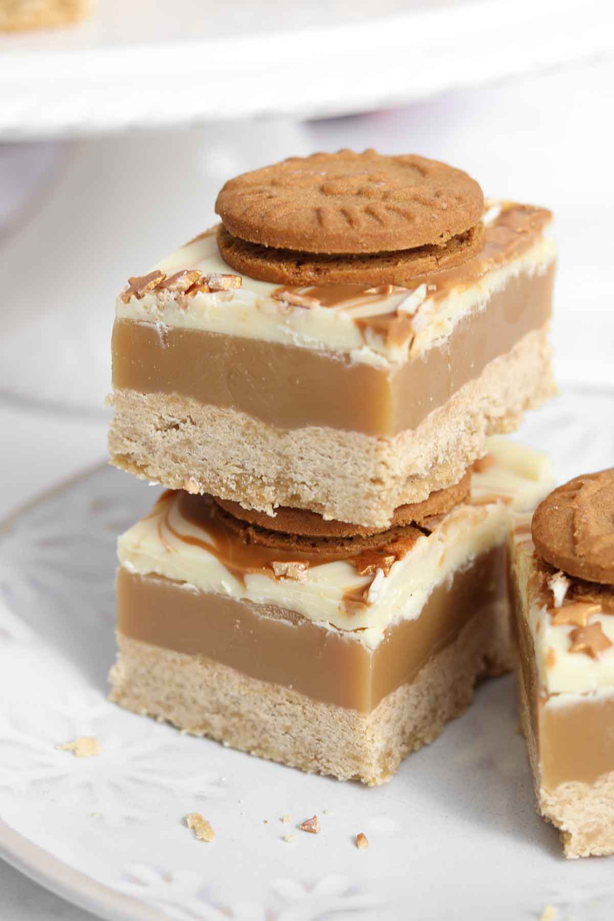 stack of two pieces of biscoff millionaire shortbread with white chocolate topping