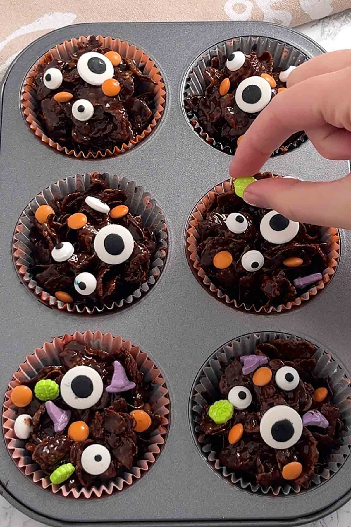 topping the cakes with halloween sprinkles