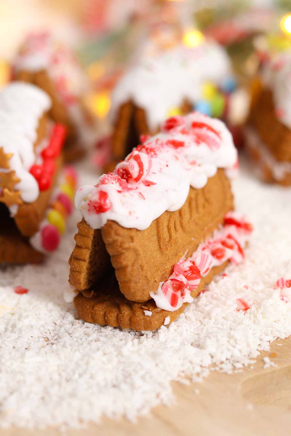 decorated biscoff gingerbread houses on a wooden board