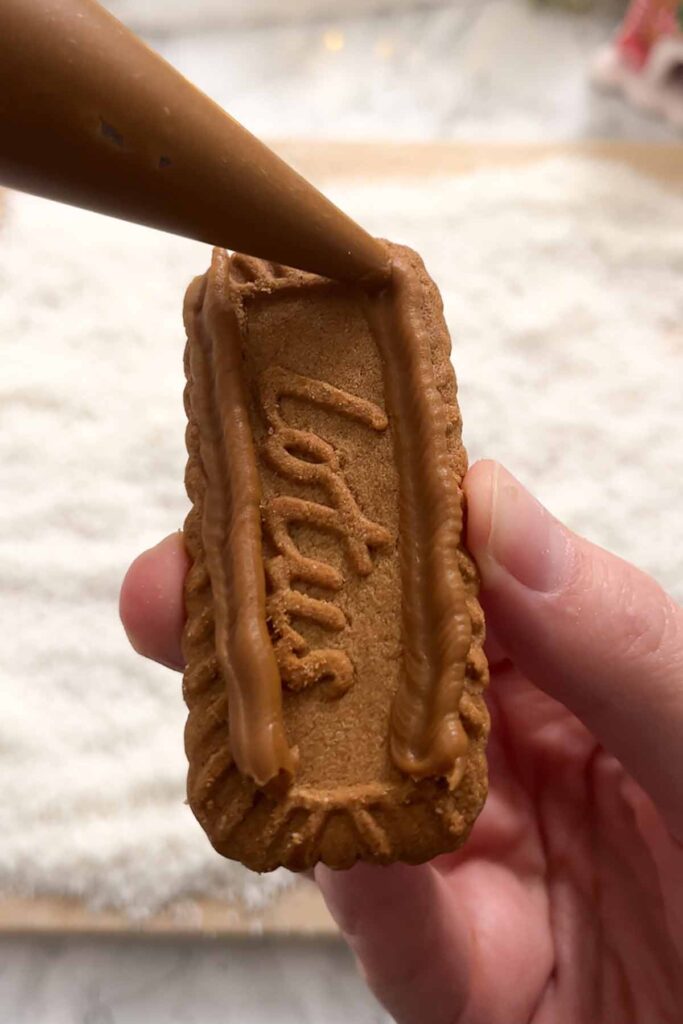 piping biscoff spread onto the biscuit