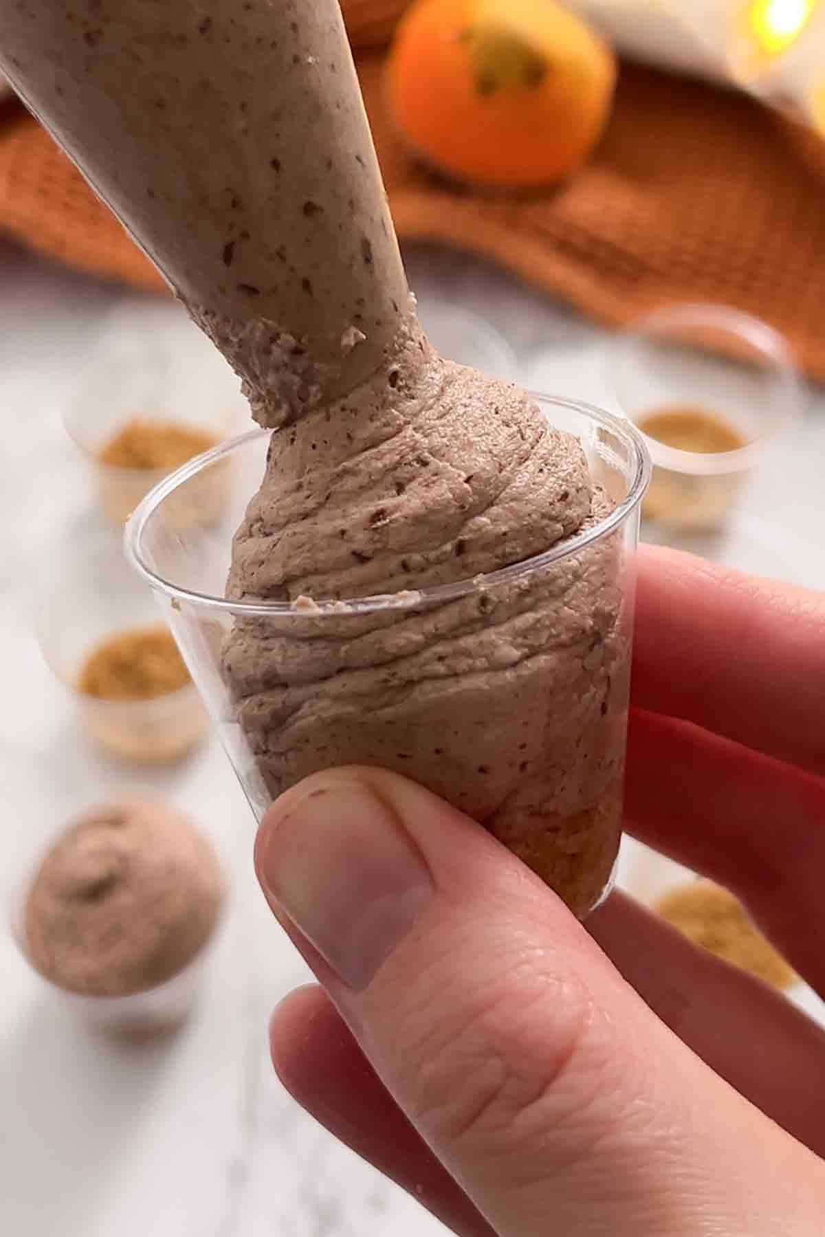 piping chocolate orange filling into shot glasses