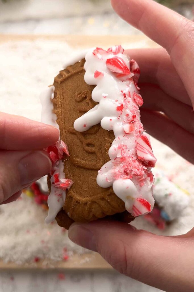 placing crushed candy canes onto the biscuit house