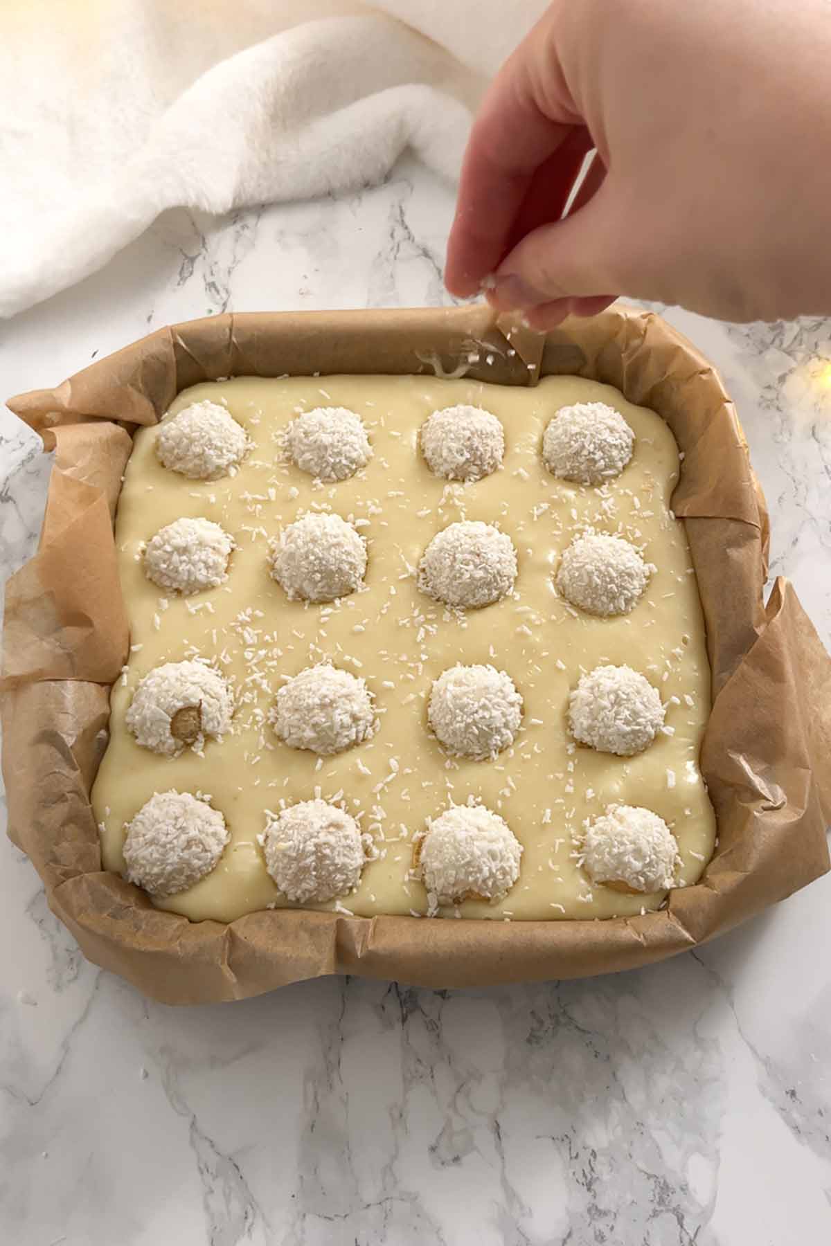 topping the fudge with raffaello truffles and desiccated coconut