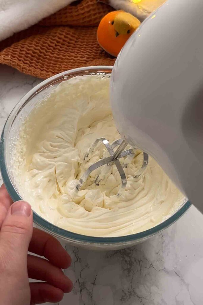 whisking cheesecake filling in a bowl