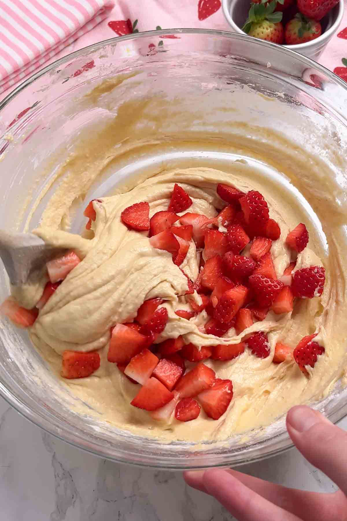 bowl of cake mix with fresh strawberry pieces on top