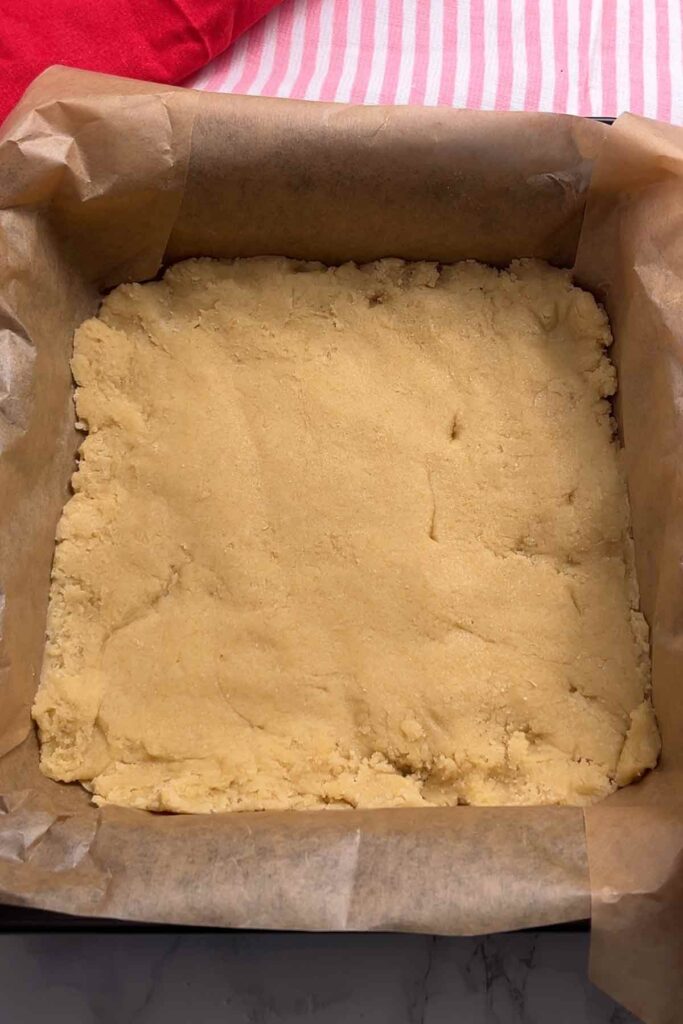 dough pressed into lined traybake tin