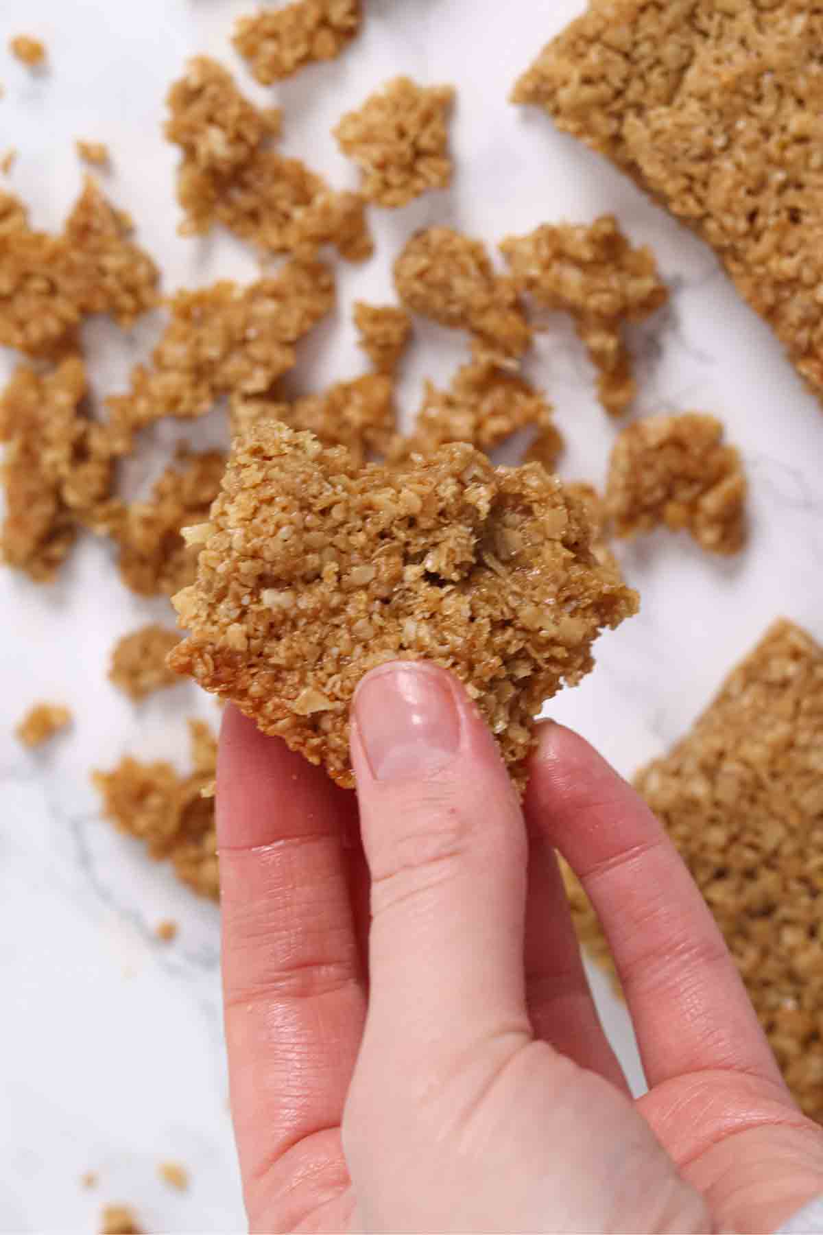 hand holding a flapjack that has fallen apart