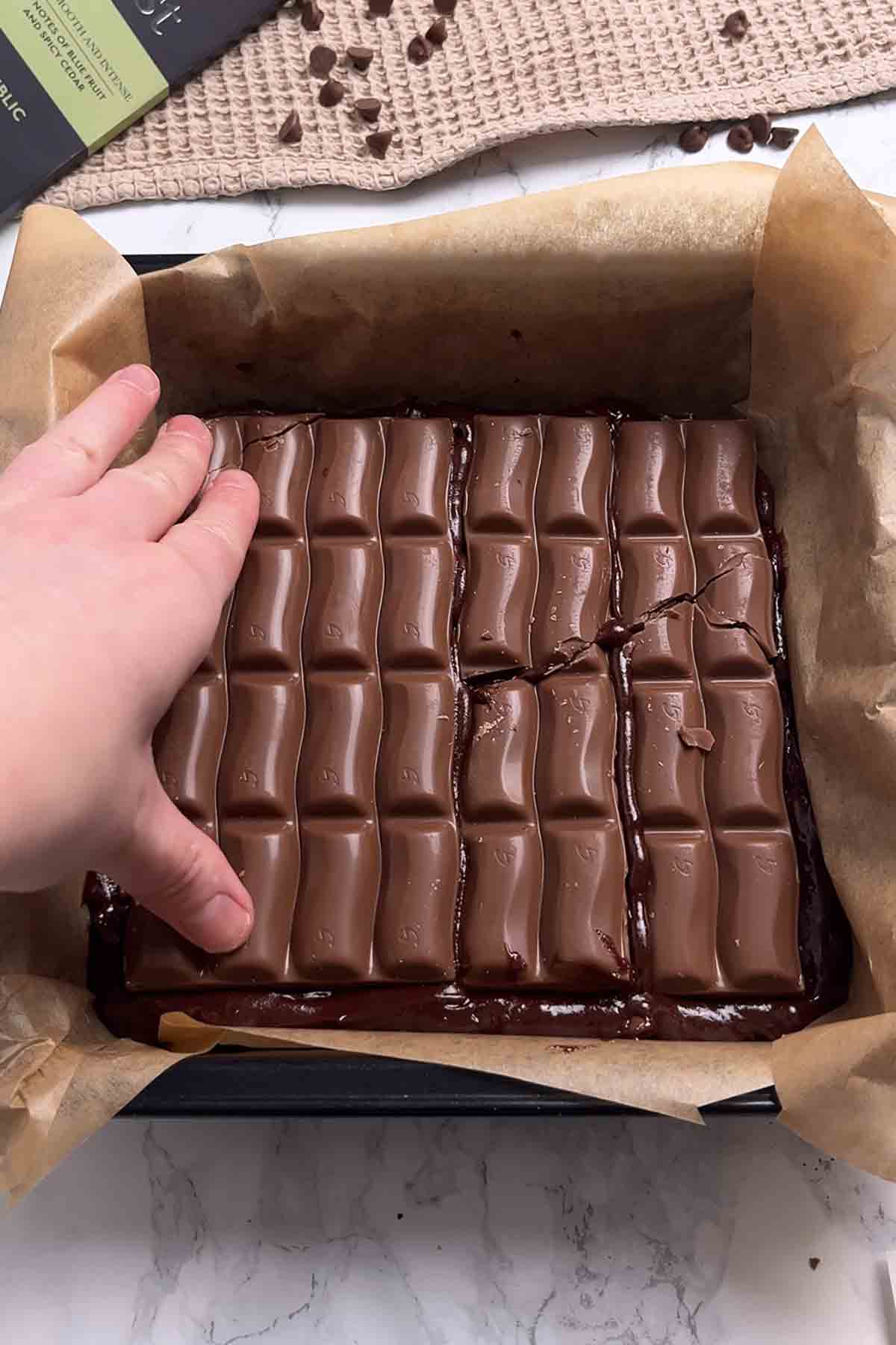 pressing galaxy caramel bars on top of brownie batter