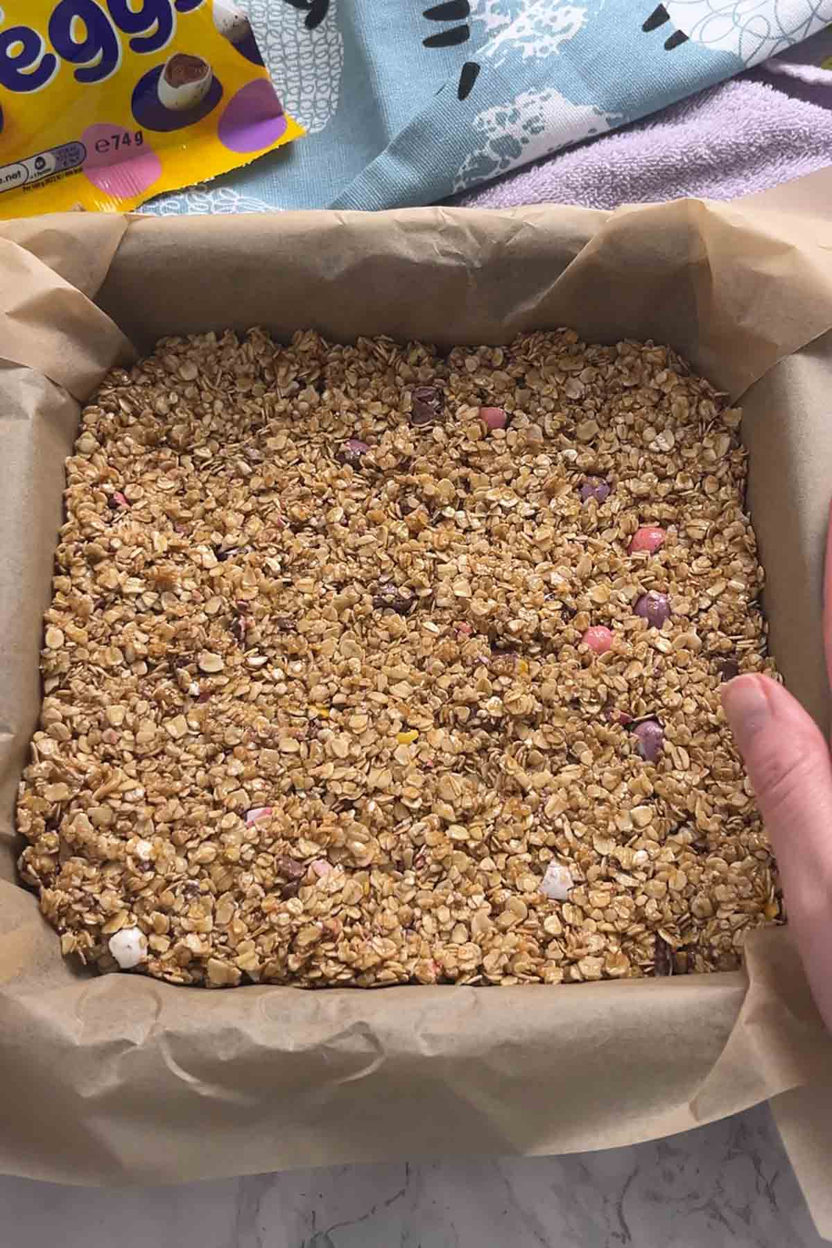 pressing mixture into the lined tin