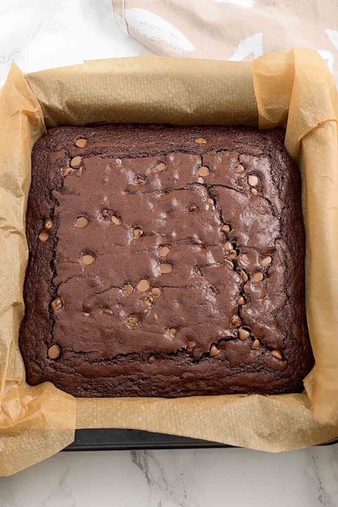 baked brownie in a lined square baking pan