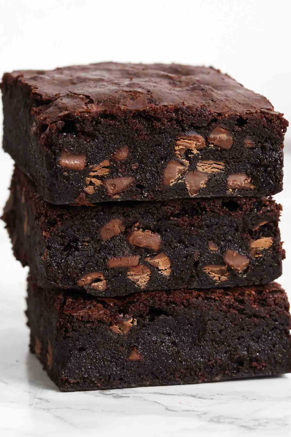 image of a stack of 3 cocoa powder brownies on a white surface