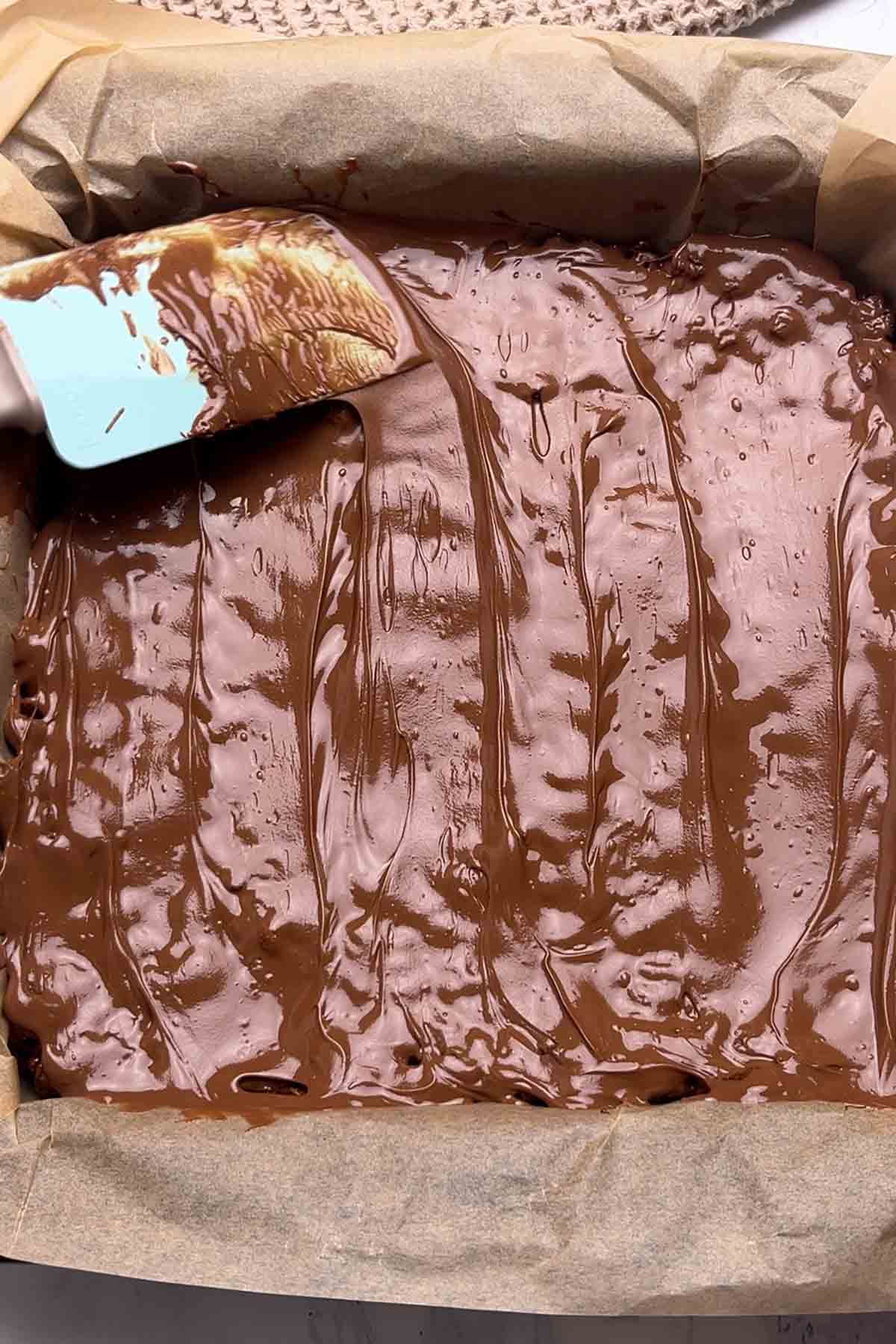 spreading melted milk chocolate on top