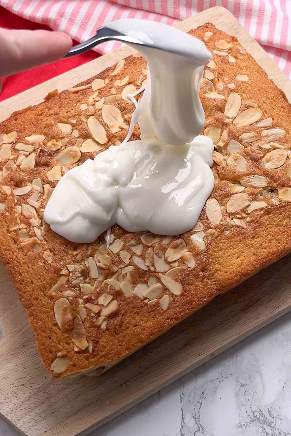 spreading the glace icing onto the cake