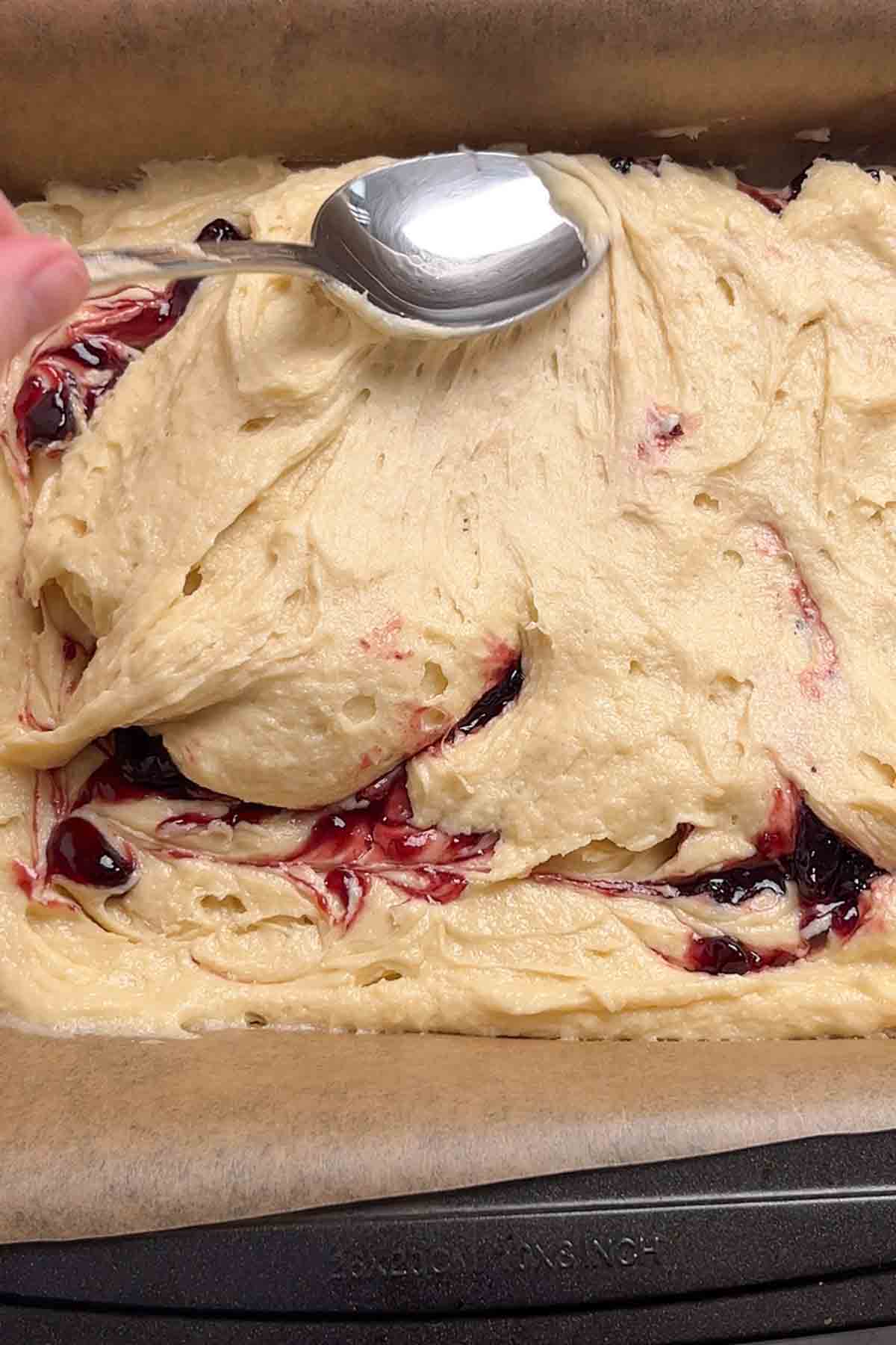 swirling cherry conserve into the cake batter