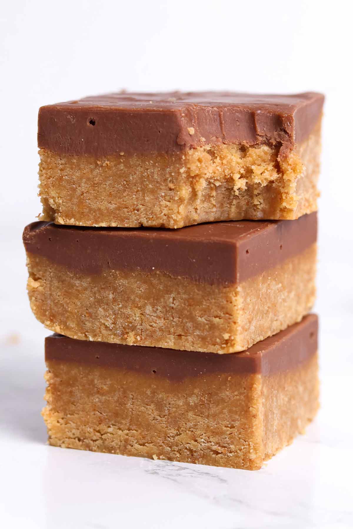 3 slices of digestive biscuit traybake with a bite taken out of the chocolate fudge topping